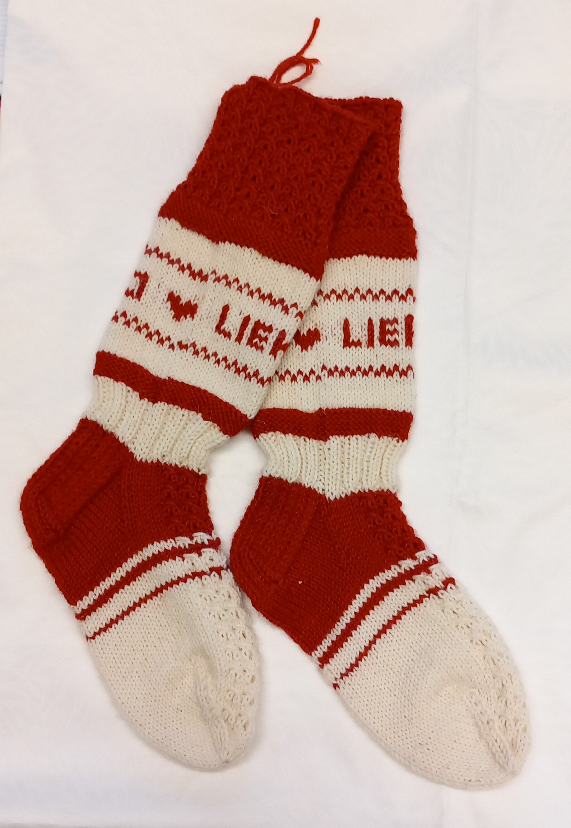 Puna-valkoiset villasukat joissa teksti Lieksa ja kuviona tekstin vieressä sydän.