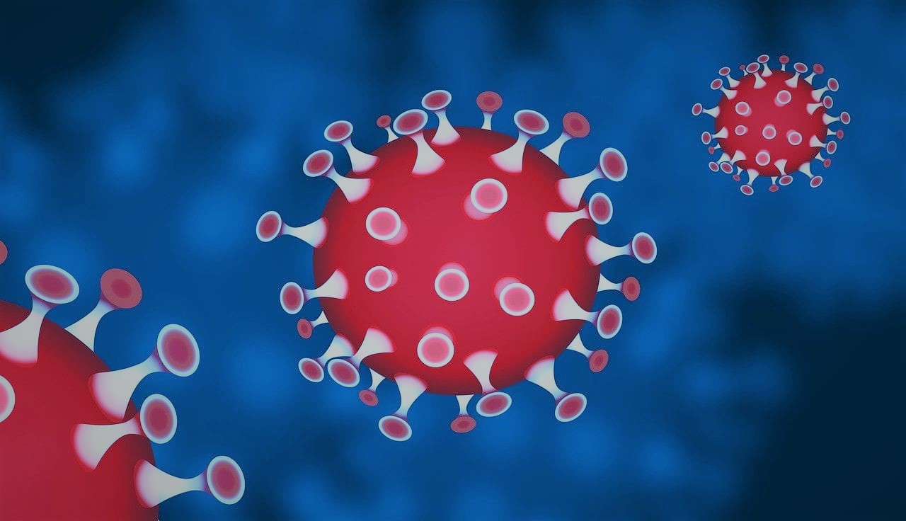 Piirretty kuva kolmesta punaisesta koronaviruksesta sinistä taustaa vasten. 