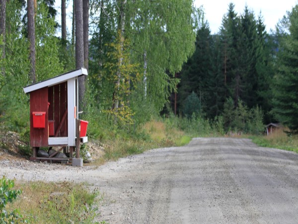 Maitolaituri tien vieressä. Laiturissa kaksi postilaatikkoa.