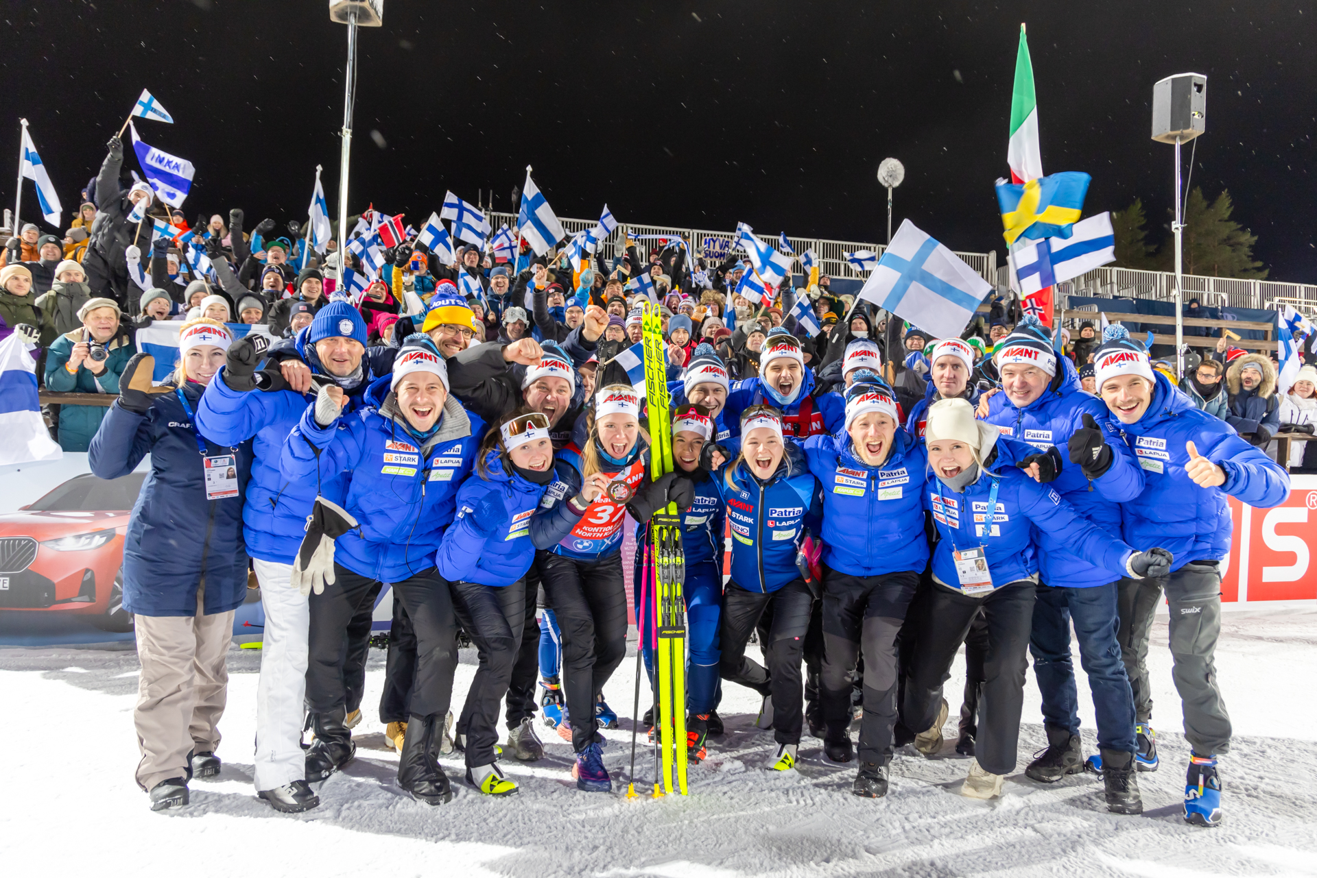Suomen ampumahiihtomaajoukkue suomalaiskannattajien edessä Kontiolahden ampumahiihtostadionilla. Kuva Esa Kinnunen